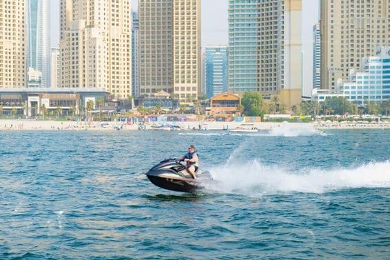Mann beim Jetskifahren in der Dubai Marina Bay.