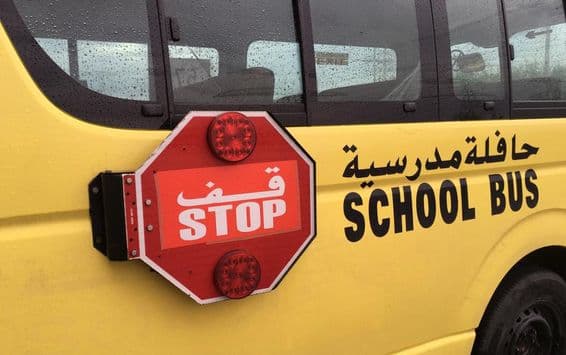 Ein leerer Schulbus mit einem roten STOP-Warnschild.