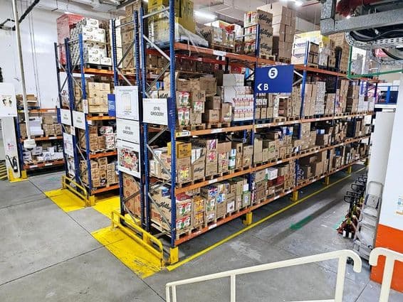 Lager mit Regalsystemen, beschrifteten Produktkategorien und Sicherheitskennzeichnungen, die reibungslose Abläufe unterstützen.