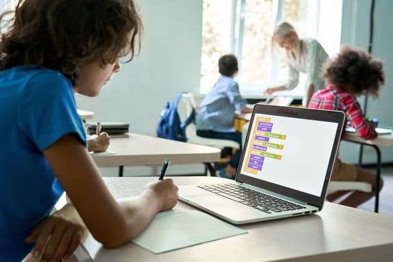 Gymnasiast verwendet einen Laptop zum Eingeben von Coding-Daten.
