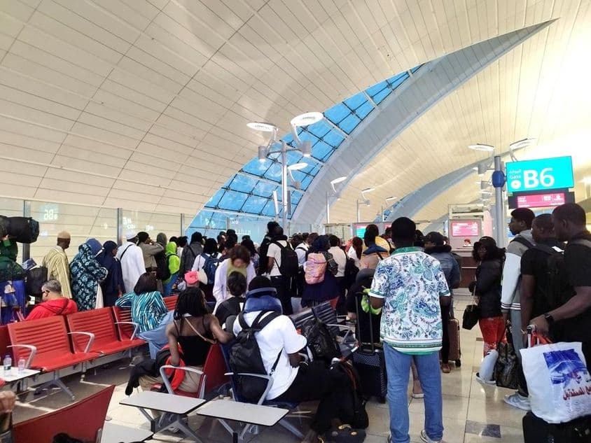 Passagiere stehen in der Schlange, um einen Flug am Dubai International Airport zu besteigen.