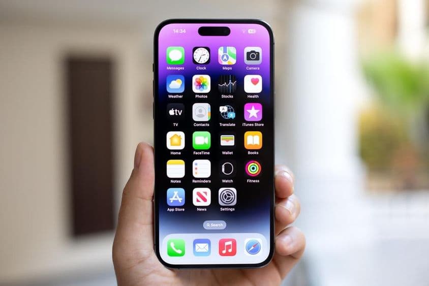 Mann hält ein iPhone 15 Pro Max mit iOS 17 auf dem Bildschirm.