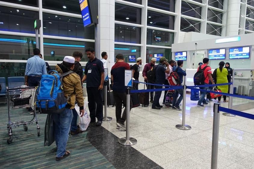 Menschen stehen in der Schlange zum Einsteigen am Gate des Dubai International Airport.
