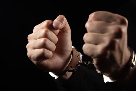 Gekettete Männer wegen Verbrechen festgenommen.