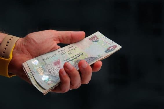 Vereinigte Arabische Emirate, Dubai-Dirham in der Hand eines Mannes.