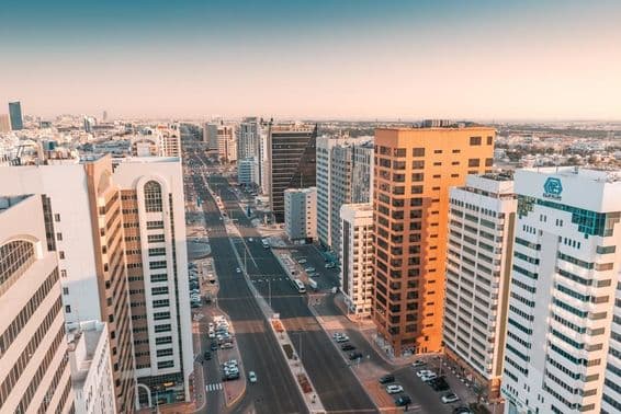 Abu Dhabi, Luftaufnahme einer breiten Straße mit Verkehr zwischen Wolkenkratzern.