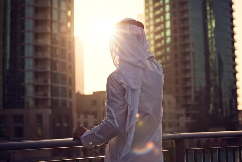Arabischer Mann beobachtet den Sonnenuntergang in Dubai.