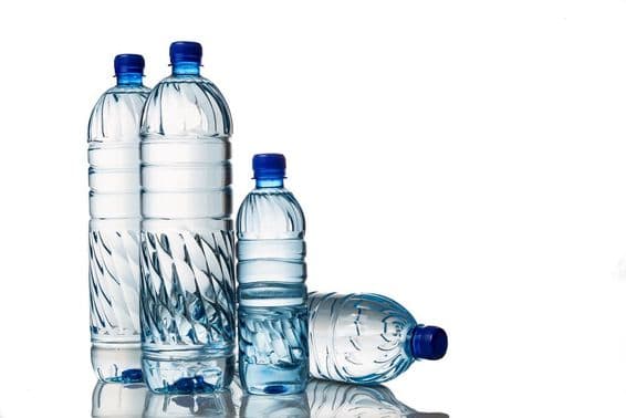Vier erfrischende natürliche Mineralwasser in Plastikflaschen.