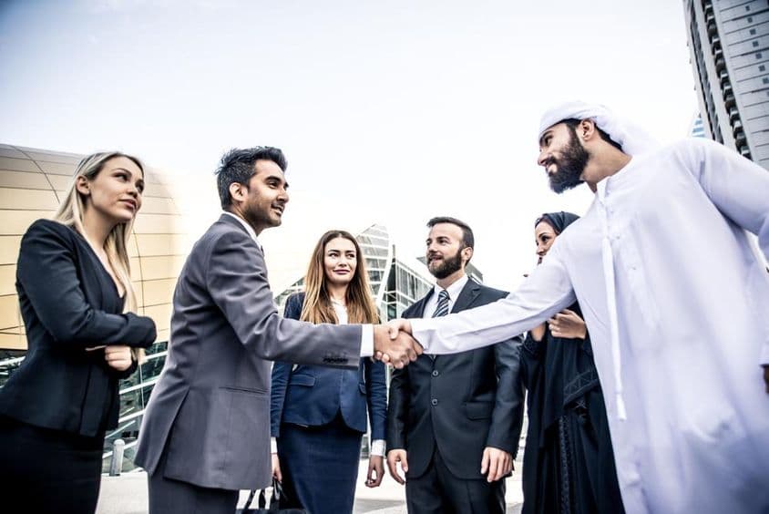 Arabische und westliche Geschäftsleute diskutieren über die Arbeit.