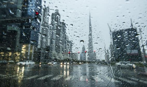 Regen in Dubai, Stadtansichten erscheinen im Hintergrund verschwommen.