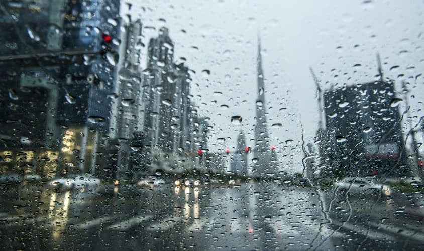 Regen in Dubai, Stadtansichten erscheinen im Hintergrund verschwommen.