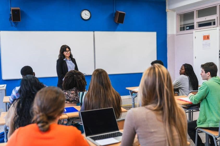 Internationale Oberschüler hören ihrem Lehrer zu.