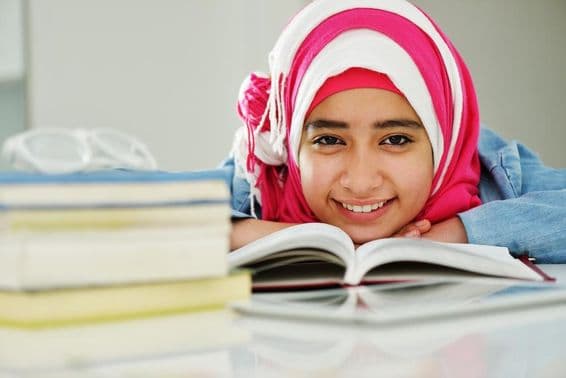 Schöne arabische muslimische Mädchen liest an der Hochschule.