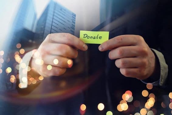 Geschäftsmann zeigt ein Dokument mit dem Wort 'Spende'.