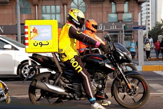 Motorradkurier liefert auf einer Straße in Dubai.