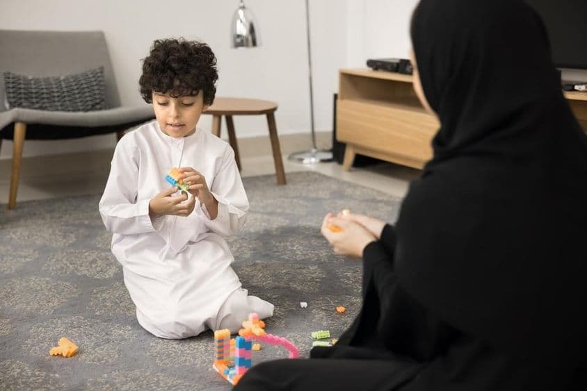 Junge arabische Frau, die mit kreativen Spielzeugen in einem muslimischen Zuhause unterrichtet.
