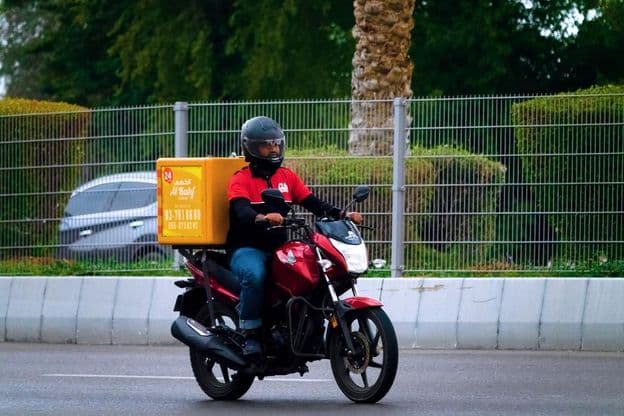 Lebensmittellieferung durch Motorradkurier in Dubai.