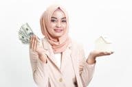 Muslimische Geschäftsfrau hält Geld für Hauskauf.