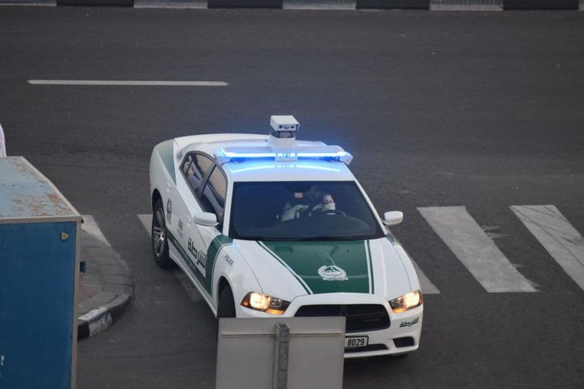 Ein Polizeiauto in Dubai fährt die Straße entlang.
