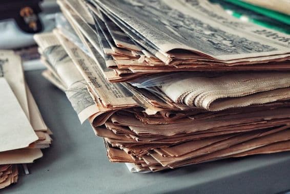 Alte Zeitungen gestapelt mit Spinnweben.