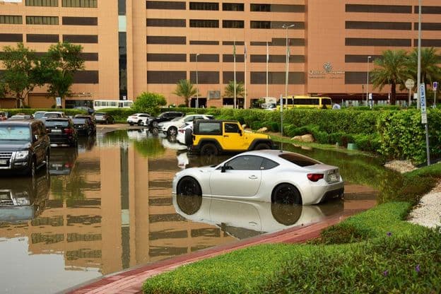 Autos in einem vom Regen durchnässten Parkplatz in Dubai.
