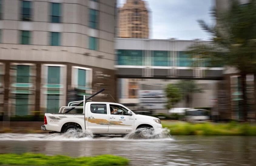 Auto fährt durch eine überflutete Straße in Dubai.