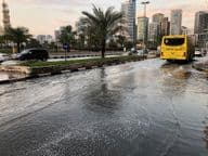 Verkehr bewegt sich durch eine überflutete städtische Straße in Dubai.