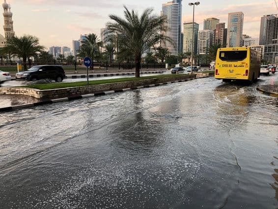 Verkehr bewegt sich durch eine überflutete städtische Straße in Dubai.