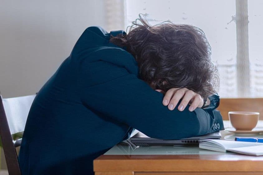 Eine Person ruht sich an einem Montag auf ihrem Laptop bei der Arbeit aus.