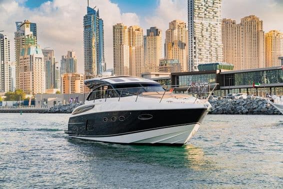 Eine Luxusyacht in Dubai mit Skyline und Wolkenkratzern.