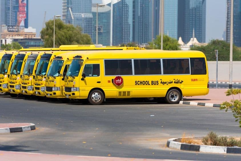 Reihe von gelben Dubai-Schulbussen, die draußen geparkt sind.