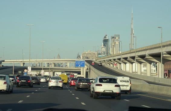 Verkehrsstau während der Stoßzeit in Dubai mit Dubais berühmten Wolkenkratzern im Hintergrund.
