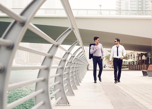 Geschäftsmänner, die in der Dubai Marina spazieren.