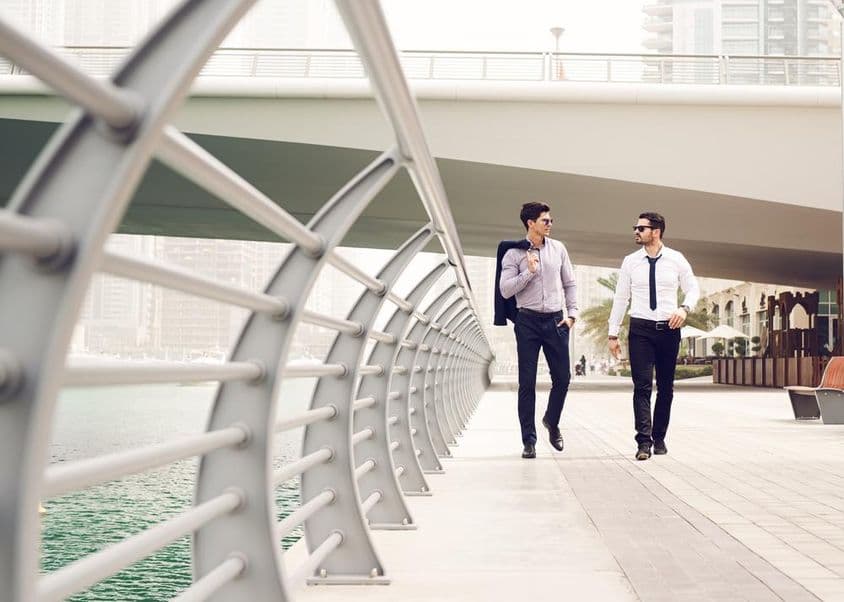 Geschäftsmänner, die in der Dubai Marina spazieren.