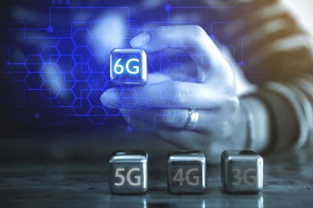 Ein junger Geschäftsmann nutzt eine kubische Stahlkugel mit der Aufschrift: 6G.