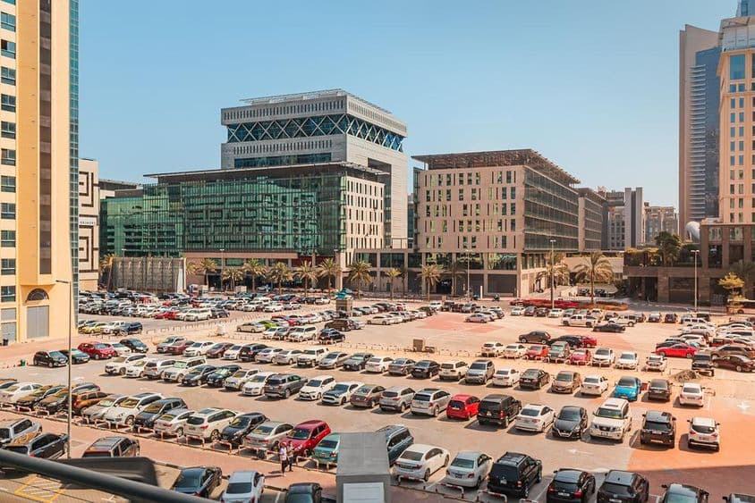 Parkplatz im Freien mit Hunderten von Autos in der Nähe von Hotel und Geschäftszentrum in Dubai.