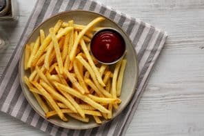 Selbstgemachte Pommes frites und Ketchup auf einem Teller.