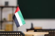 Die Flagge der Vereinigten Arabischen Emirate auf einem Schreibtisch im Klassenzimmer
