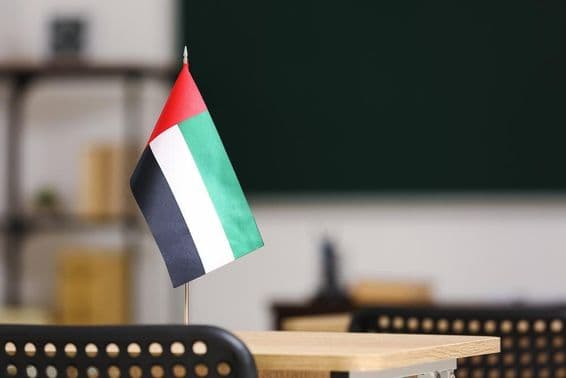 Die Flagge der Vereinigten Arabischen Emirate auf einem Schreibtisch im Klassenzimmer