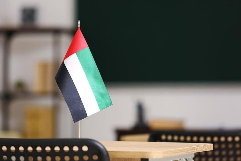 Die Flagge der Vereinigten Arabischen Emirate auf einem Schreibtisch im Klassenzimmer