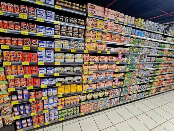 Supermarktregal mit bunten Konserven, Thunfisch und Gemüse