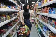 Eine junge Araberin betrachtet Snacks in einem Supermarkt.