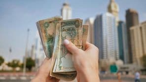 Die Währung der Vereinigten Arabischen Emirate vor der Kulisse der Wolkenkratzer von Dubai.