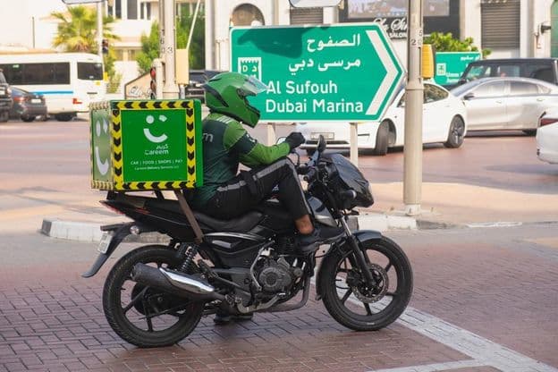 Motorradfahrer vom umweltfreundlichen grünen Lieferdienst von Careem.