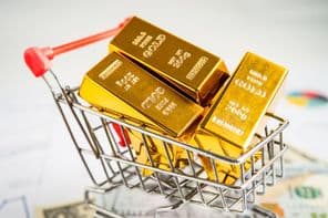 Goldbarren in einem Einkaufswagen auf amerikanischen Dollarnoten