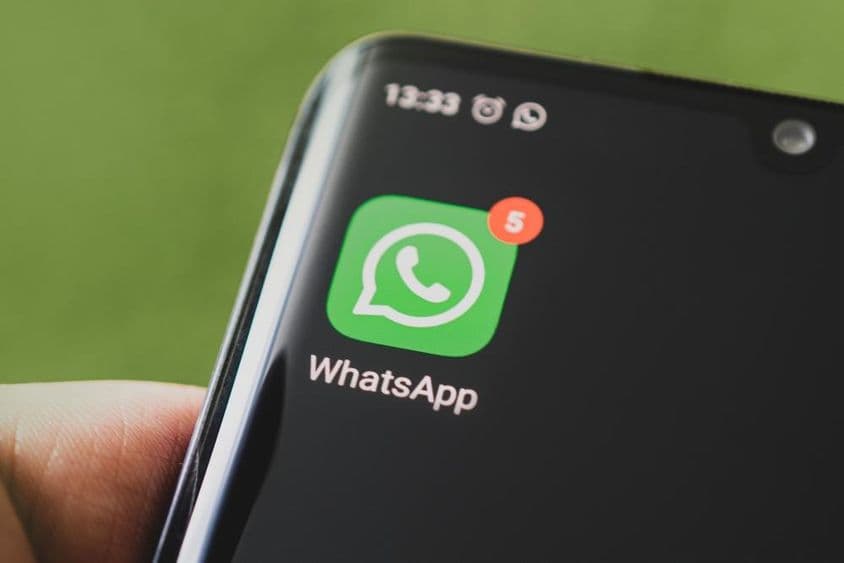 Das WhatsApp-Icon auf einem schwarzen Smartphone-Bildschirm.