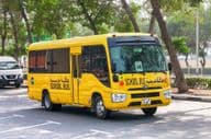 Toyota Coaster Schulbus auf einer Straße in Dubai.