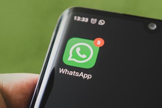 WhatsApp-Symbol auf einem schwarzen Smartphone