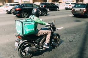 Kurier liefert Essen auf einem Roller.