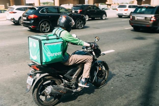 Kurier liefert Essen auf einem Roller.